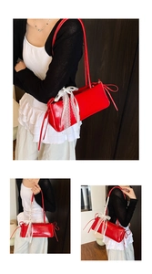Détail du sac à bandoulière en cuir rouge avec nœud en dentelle blanche et rubans