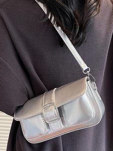 Chic silver metallic underarm square bag with large metal buckle on a model