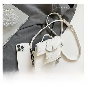 Petit sac bandoulière blanc avec boucle argentée à côté d'un smartphone pour comparer la taille
