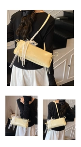 Détail du sac à bandoulière jaune pâle en cuir poli avec un nœud en dentelle