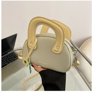 Détail du mini sac vert avec poignée jaune et pendentif fleur décoratif