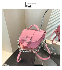 Détail d'un sac à main rose en cuir grainé avec boucle anneau argentée et chaîne