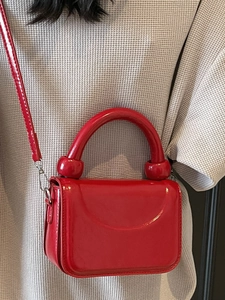 Petit sac à main minimaliste en cuir verni rouge avec poignée arrondie et détails sphériques