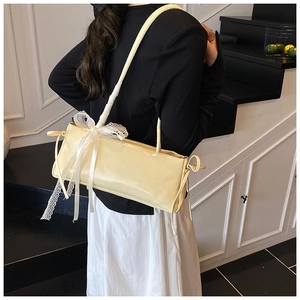 Détail du sac à bandoulière blanc cassé avec nœud en dentelle et cuir synthétique lisse