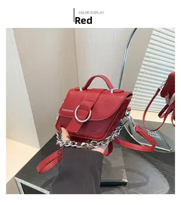 Détail d'un sac en cuir grainé rouge avec anneau métallique argenté et chaîne