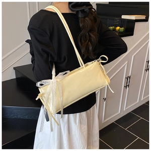 Vue détaillée du sac porté épaule crème avec un grand nœud en dentelle blanche