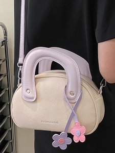 Sac Boston chic en cuir beige avec poignée anneau violette et breloque fleurie