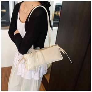 Gros plan détaillé du sac bandoulière crème avec dentelle blanche et rubans décoratifs fins