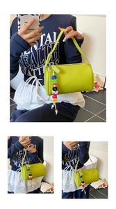 Detail of lemon green cylindrical pillow bag with lychee texture and beaded charm