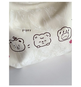 Close-up of white wrinkled fabric texture featuring minimalist cute puppy illustrations
