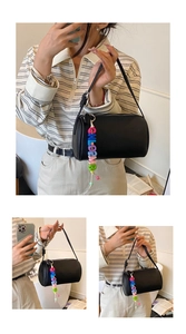 Detail of black pebbled leather barrel bag with colorful CHLOEM letter charms and zipper