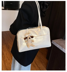 Detail of white glossy leather tote bag with CHIC SMU logo and cute puppy pendant