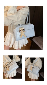 Detail of light blue glossy tote bag with cute puppy plush charm and long shoulder strap