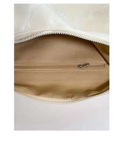 Detail view of white underarm bag showing spacious interior with zipper pocket and lining