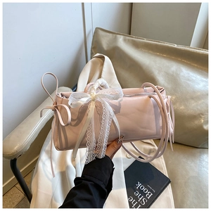 Détail du sac à main en similicuir rose clair avec un nœud en dentelle blanche
