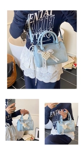 Detail of light blue pebble grain Boston bag with pearl heart lace bow accessory