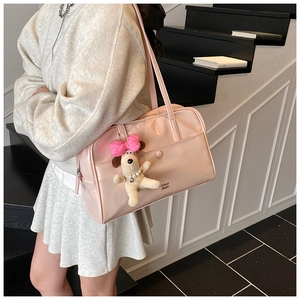 Detail of light pink tote bag with pearly finish and cute puppy plush charm on a model