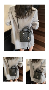 Detail der schwarzen geflochtenen Eimertasche mit Herzanhänger und Schultergurt