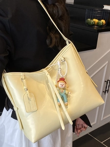 Chic yellow soft faux leather tote bag for women with a cute doll pendant and long strap