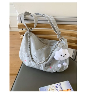 Detail of light gray pleated shoulder bag with bear print and cloud plush charm