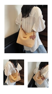 Detail of hand-woven straw tote with brown leather strap and cute sheep charm