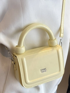Sac à main minimaliste jaune crème avec logo métallique argenté et poignée supérieure
