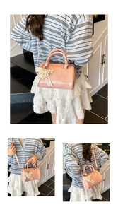 Pink Boston bag detail featuring pearl heart charm and lace bow decoration
