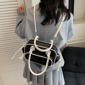 Back view of a black and white minimalist multi-purpose bag shown on a model