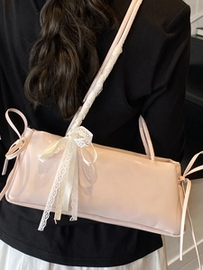 Sac à bandoulière rose en similicuir avec nœuds en dentelle blanche vu de l'arrière