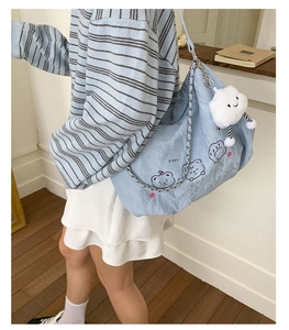 Detail of light blue pleated shoulder bag with cute bears and white cloud plush charm