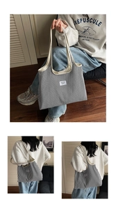 Detail view of the black and white striped canvas tote bag with woven logo label