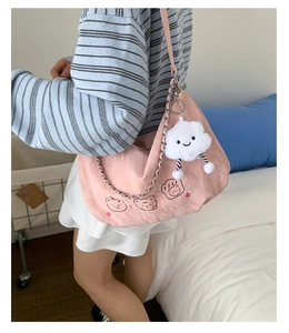 Detailed view of pink shoulder bag with cartoon bear print and fluffy cloud charm