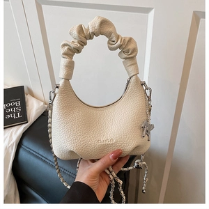 Detail of off-white pleated leather handbag with chain strap and horse charm detail