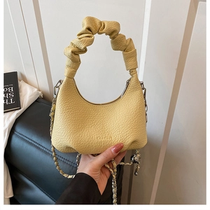 Detail of lychee pattern leather dumpling bag with ruched handle and silver chain strap
