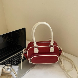 Detail of red and white contrasting handbag with side bows in a modern office setup