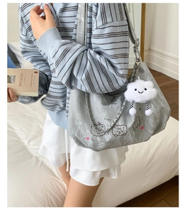 Detail of silver tote bag with metallic chain, puppy print and plush cloud charm decor