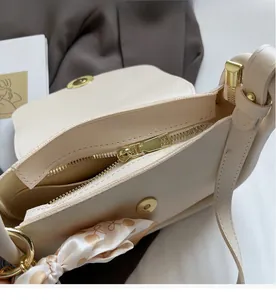 Vue détaillée du sac crème montrant la fermeture éclair, la poche interne et le foulard