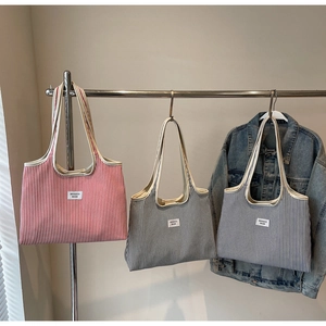 Detailed view of large canvas tote bags with classic vertical stripes in red, black, and blue