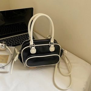 Detail view of contrast black and white mini boston bag with dual handles and shoulder strap