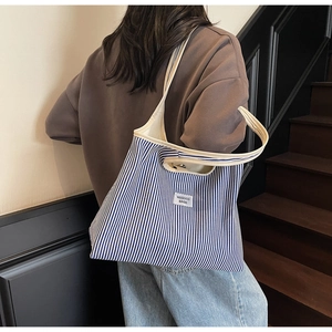 Detail of blue and white striped canvas tote bag with WEGOCO BAGS label on wooden steps