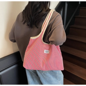 Detailed back view of a large red and white striped canvas tote bag with wide straps
