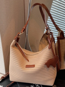 Fashionable large beige woven straw tote bag with brown leather straps and bear charm