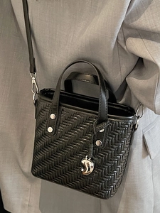 Elegante schwarze gewebte Beuteltasche mit Silberbeschlägen und Schultergurt am Modell gezeigt