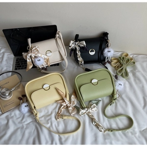 Détail de quatre sacs carrés colorés avec foulards en soie et pendentifs en peluche