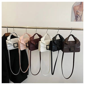 Plusieurs couleurs de mini sacs carrés en similicuir serpent suspendus sur un support