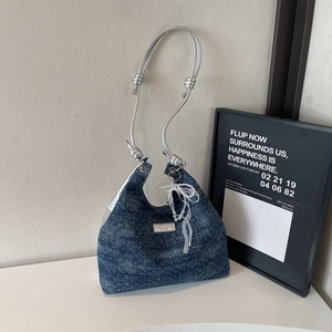 Macro shot of denim texture handbag with shiny rhinestones and woven rope handle