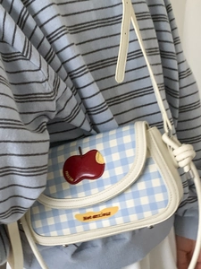 Blue and white plaid saddle bag with red apple embroidery and white faux leather strap