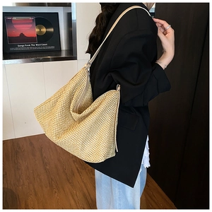 Detail of beige woven tote bag with slim faux leather strap and smooth silver zipper