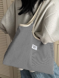 Minimalist black and white striped canvas tote bag with cream trim and shoulder straps