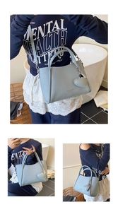 Détail d'un sac seau bleu clair en cuir grainé avec pendentif coeur et bandoulière